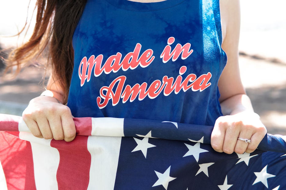 A girl holding the American flag and a Made in America t-shirt