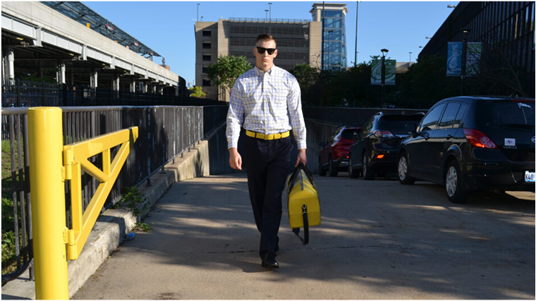 A person carrying a yellow duffle bag