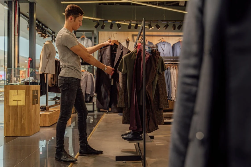 An image of a man looking at clothes in a shop